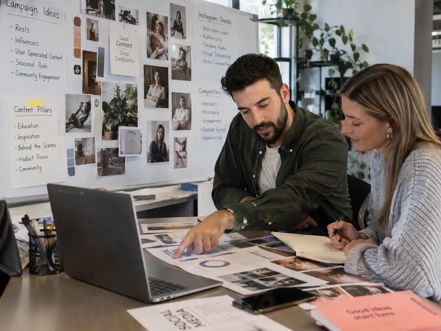 Social media managers analyzing Instagram content trends and campaign ideas together in an office